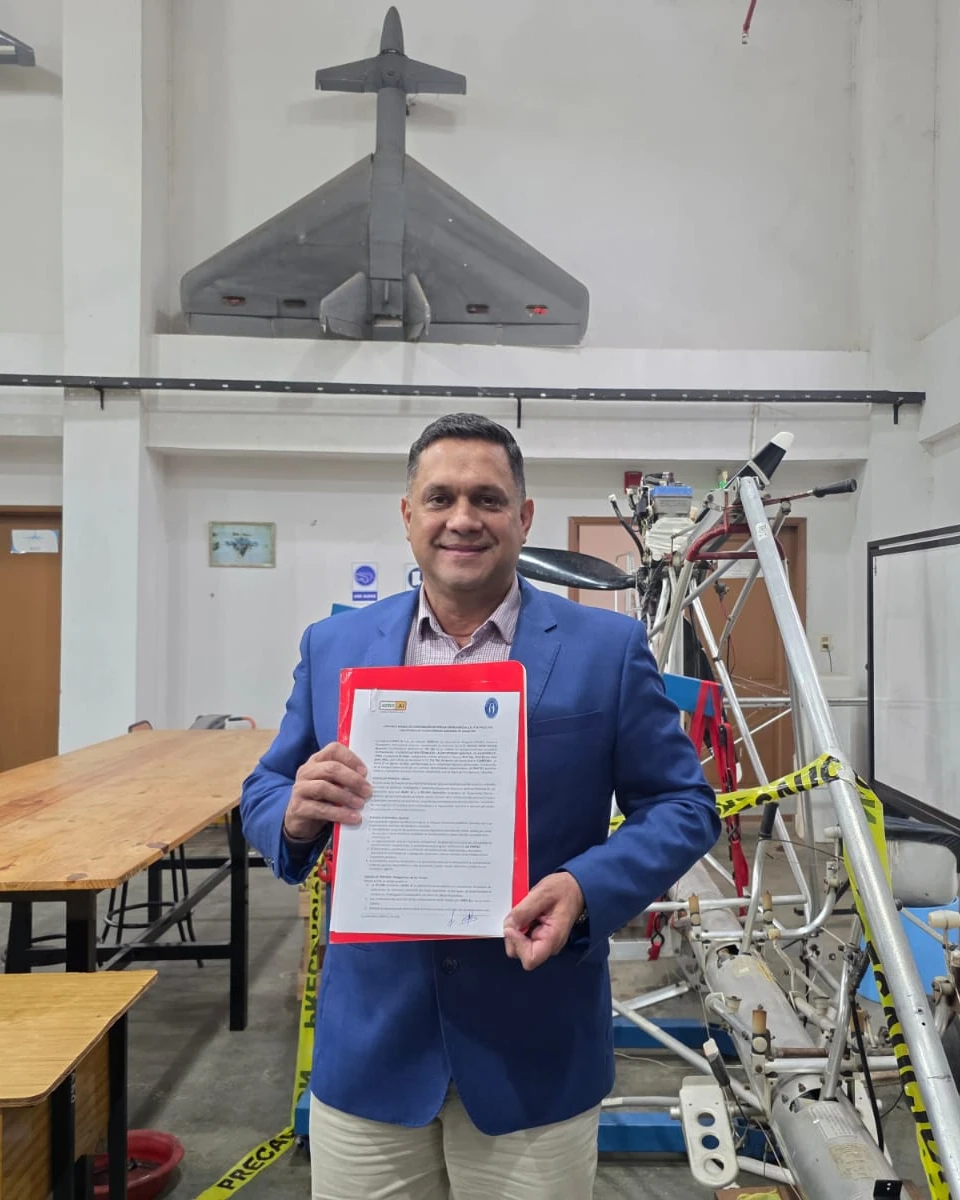 El Ing. Gerardo Monzón Manzoni muestra el convenio firmado en el taller, junto a la estructura del prototipo